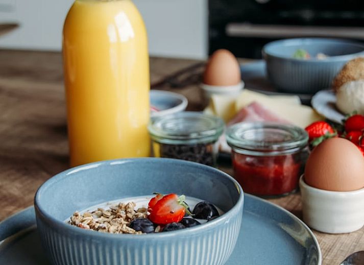 Moderne woonkamer van Vakantiehuis in Ritthem, Walcheren, met eetgedeelte en trap.