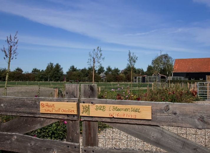 Moderne woonkamer van Vakantiehuis in Ritthem, Walcheren, met eetgedeelte en trap.