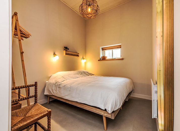 Ruime tuin van Vakantiehuis De kleine Pionier in Grijpskerke, Walcheren, Zeeland met ligstoelen en groene omgeving.