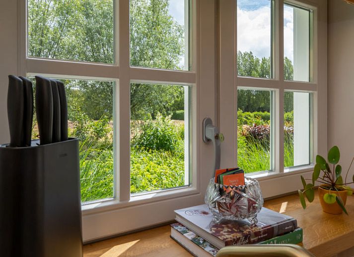 Gezellige binnenruimte van Vakantiehuis De kleine Pionier in Grijpskerke met uitzicht op de tuin, Walcheren, Zeeland.