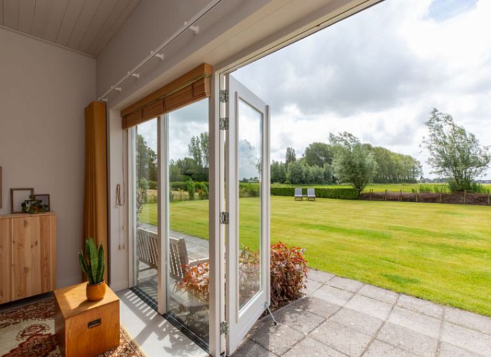 Gezellige binnenruimte van Vakantiehuis De kleine Pionier in Grijpskerke met uitzicht op de tuin, Walcheren, Zeeland.