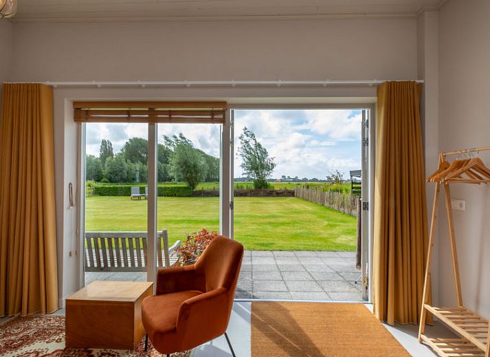 Gezellige binnenruimte van Vakantiehuis De kleine Pionier in Grijpskerke met uitzicht op de tuin, Walcheren, Zeeland.
