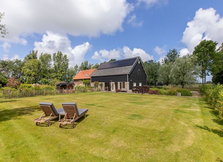 Bloemrijke tuin van Vakantiehuis De kleine Pionier in Grijpskerke, Walcheren, Zeeland met uitzicht op de natuur.