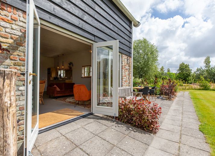 Bloemrijke tuin van Vakantiehuis De kleine Pionier in Grijpskerke, Walcheren, Zeeland met uitzicht op de natuur.