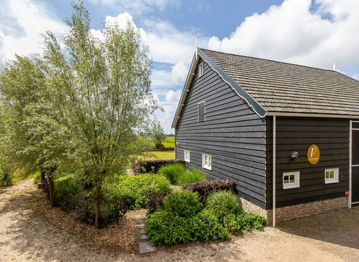 Bloemrijke tuin van Vakantiehuis De kleine Pionier in Grijpskerke, Walcheren, Zeeland met uitzicht op de natuur.