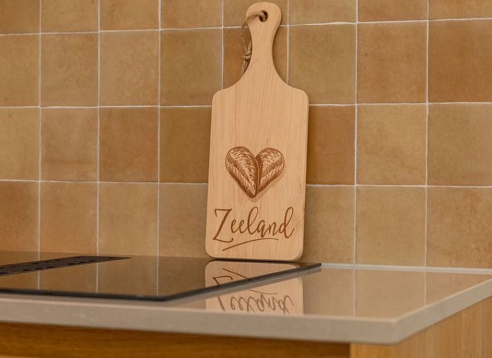 Terras van Vakantiehuis De kleine Pionier in Grijpskerke, Walcheren, Zeeland met zitgelegenheid en toegang tot de tuin.