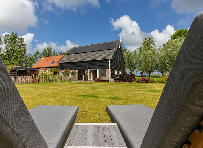 Terras van Vakantiehuis De kleine Pionier in Grijpskerke, Walcheren, Zeeland met zitgelegenheid en toegang tot de tuin.