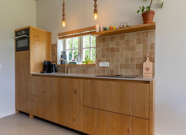 Terras van Vakantiehuis De kleine Pionier in Grijpskerke, Walcheren, Zeeland met zitgelegenheid en toegang tot de tuin.