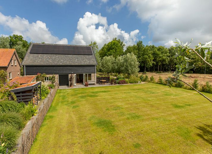 Terras van Vakantiehuis De kleine Pionier in Grijpskerke, Walcheren, Zeeland met zitgelegenheid en toegang tot de tuin.