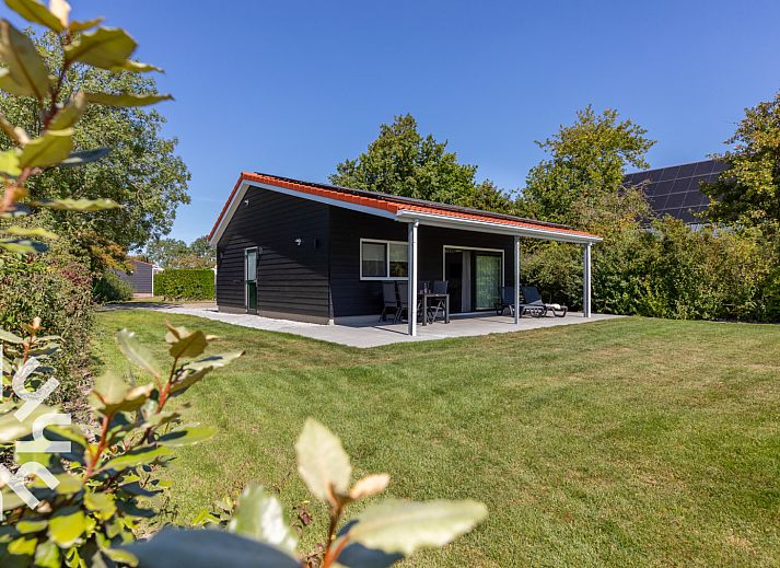 Zonnig terras van vakantiehuis ZE1470 in Grijpskerke, Walcheren, met ligstoelen en tijdschrift.