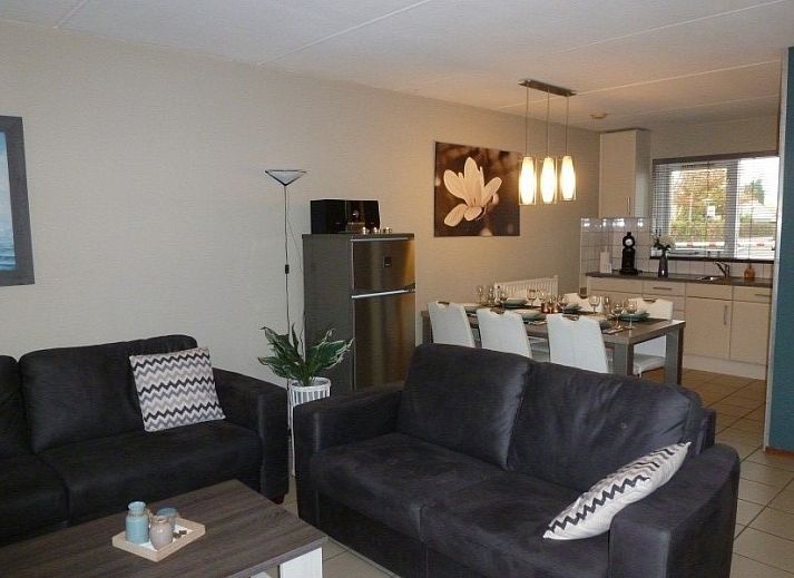 Gezellige woonkamer in vakantiehuis Fort Soleil, Breskens, met moderne inrichting en comfortabele zithoek, perfect voor ontspanning.