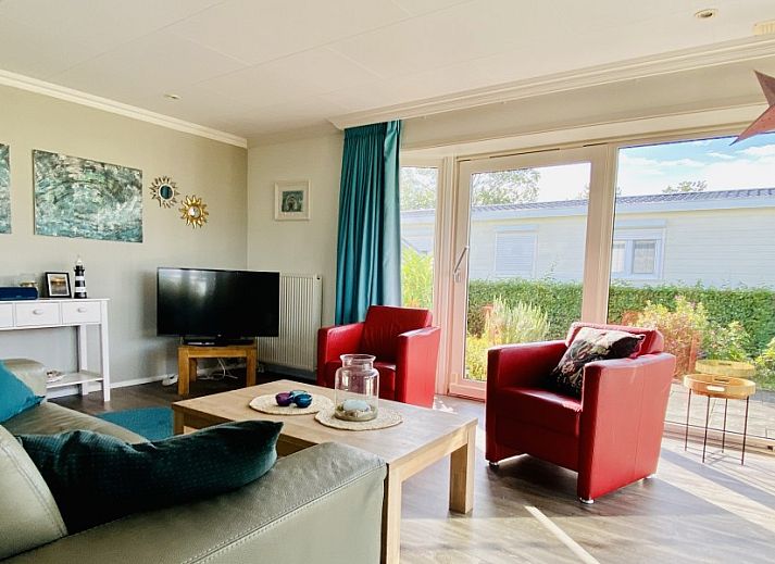 Gezellige woonkamer in Casa Mari, een chalet in Breskens, Zeeuws-Vlaanderen, met veel natuurlijk licht en comfortabel interieur.