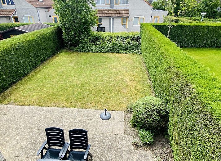 Gemuetliches Wohnzimmer von VZ407 Ferienhaus Breskens, mit Sitzecke und Gartenblick.