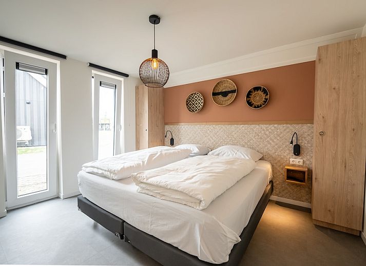 Entspanntes Wohnzimmer in Koosvilla Luxe 4+2, einem Ferienhaus in Breskens, Zeeuws-Vlaanderen, Zeeland mit moderner Einrichtung und bequemen Sitzgelegenheiten.