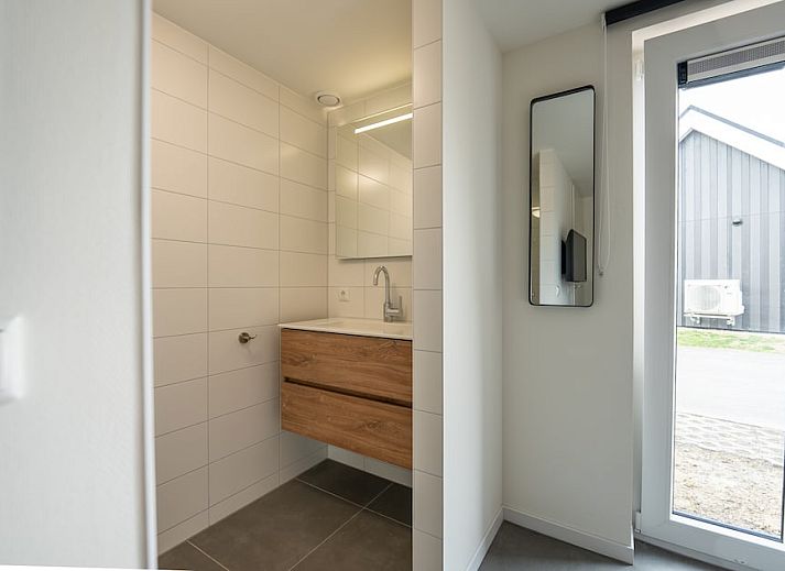 Entspanntes Wohnzimmer in Koosvilla Luxe 4+2, einem Ferienhaus in Breskens, Zeeuws-Vlaanderen, Zeeland mit moderner Einrichtung und bequemen Sitzgelegenheiten.