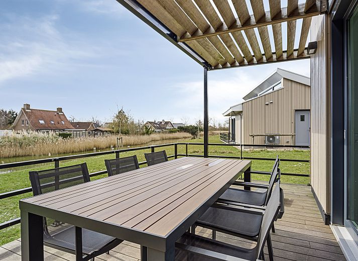 Heldere entree van de Vrijstaande woning in Breskens, vakantiehuis in Zeeuws-Vlaanderen, met moderne inrichting en toegang tot de woonkamer.