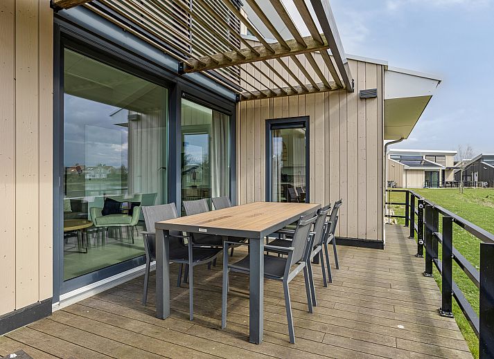 Heldere entree van de Vrijstaande woning in Breskens, vakantiehuis in Zeeuws-Vlaanderen, met moderne inrichting en toegang tot de woonkamer.