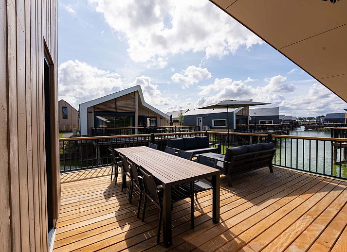 Stijlvolle woonkamer van Vrijstaande woning in Breskens, vakantiehuis in Zeeland met grote ramen en veel natuurlijk licht.