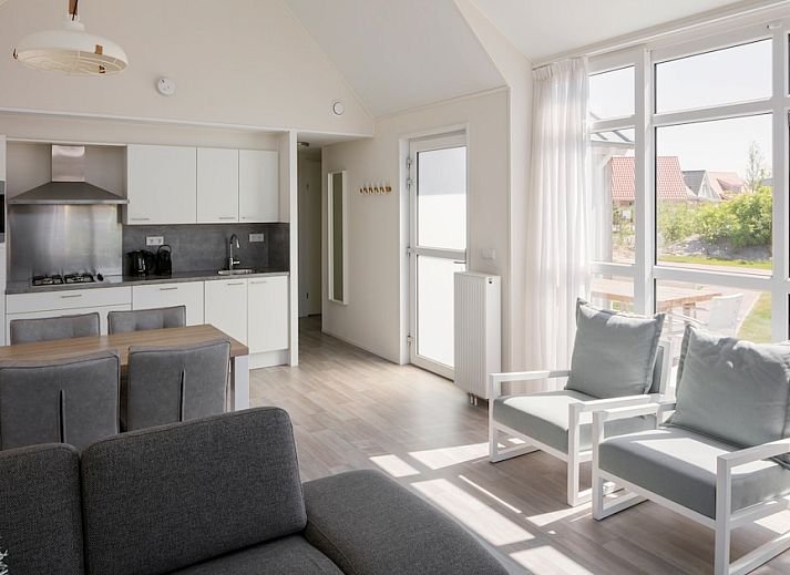 L6B Komfort-Ferienhaus in Nieuwvliet-Bad, Zeeland mit Holzfassade und Terrasse, umgeben von Duenen und Natur.