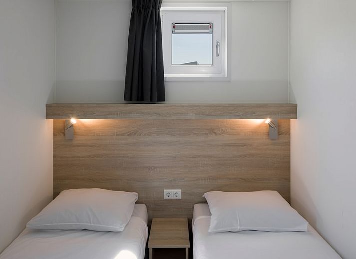 L6B Komfort-Ferienhaus in Nieuwvliet-Bad, Zeeland mit Holzfassade und Terrasse, umgeben von Duenen und Natur.