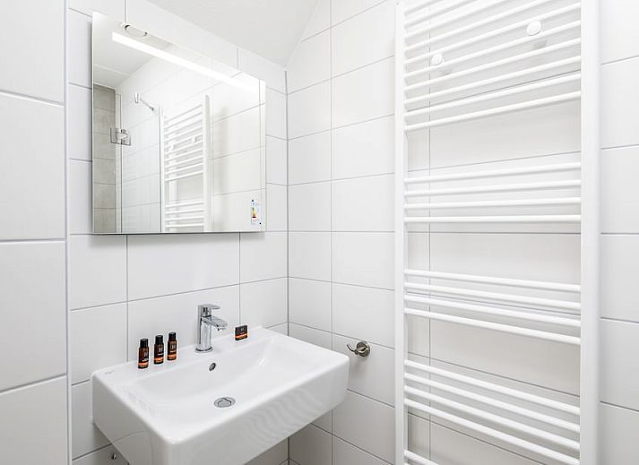 Gemuetliches Wohnzimmer im V8 Luxus-Ferienhaus in Nieuwvliet-Bad, Zeeland, mit komfortabler Sitzecke.