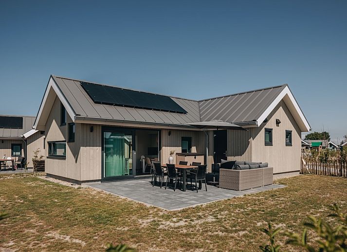 Die Babylodge 4+1 in Nieuwvliet-Bad, ein Ferienhaus in Zeeland, bietet eine einladende Terrasse und einen modernen Aussenbereich zum Entspannen.