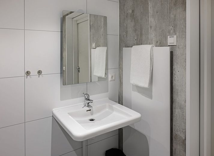 Gezellige woonkamer in Mindervalide 4 vakantiehuis, Nieuwvliet-Bad, Zeeuws-Vlaanderen met moderne inrichting en veel natuurlijk licht.