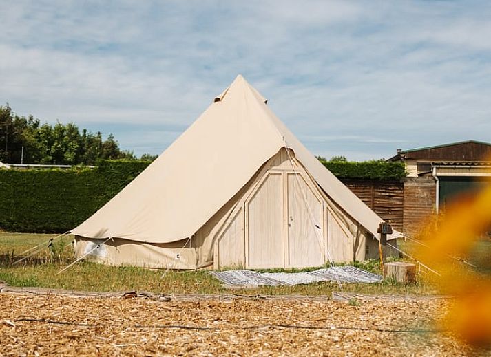 Kind spielt mit Ball im Safarizelt in einem Ferienhaus in Nieuwvliet-Bad, Zeeuws-Vlaanderen, Zeeland.