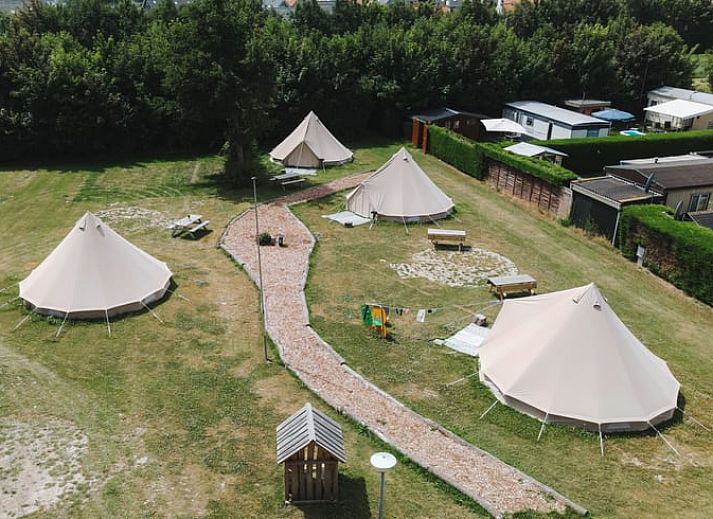 Kind spielt mit Ball im Safarizelt in einem Ferienhaus in Nieuwvliet-Bad, Zeeuws-Vlaanderen, Zeeland.