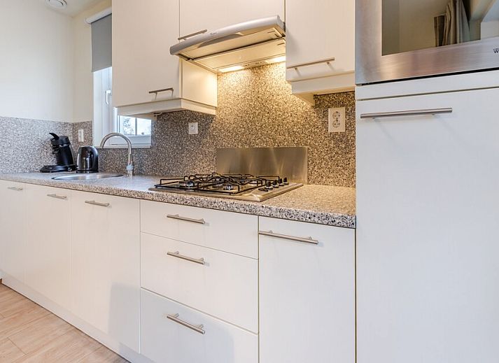 Sfeervolle slaapkamer in Villa 6B, een vakantiehuis in Cadzand-bad, Zeeuws-Vlaanderen, met comfortabele bedden en warme verlichting.