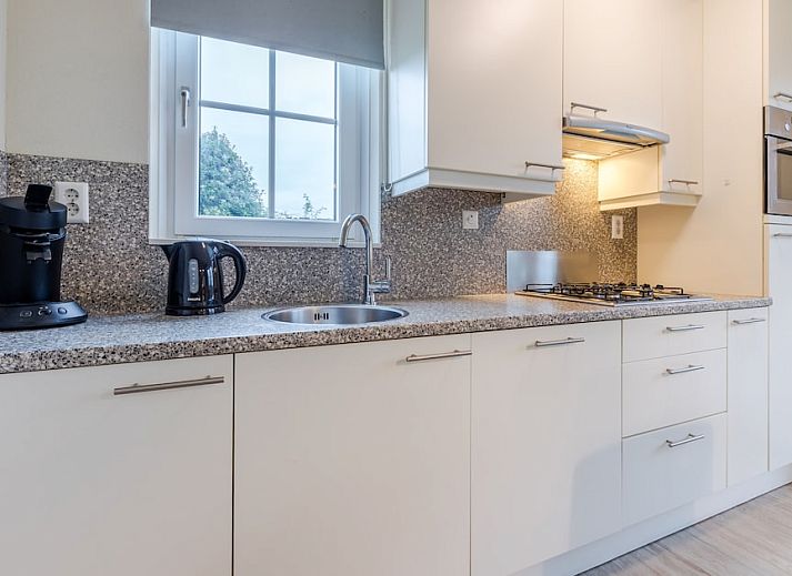 Sfeervolle slaapkamer in Villa 6B, een vakantiehuis in Cadzand-bad, Zeeuws-Vlaanderen, met comfortabele bedden en warme verlichting.