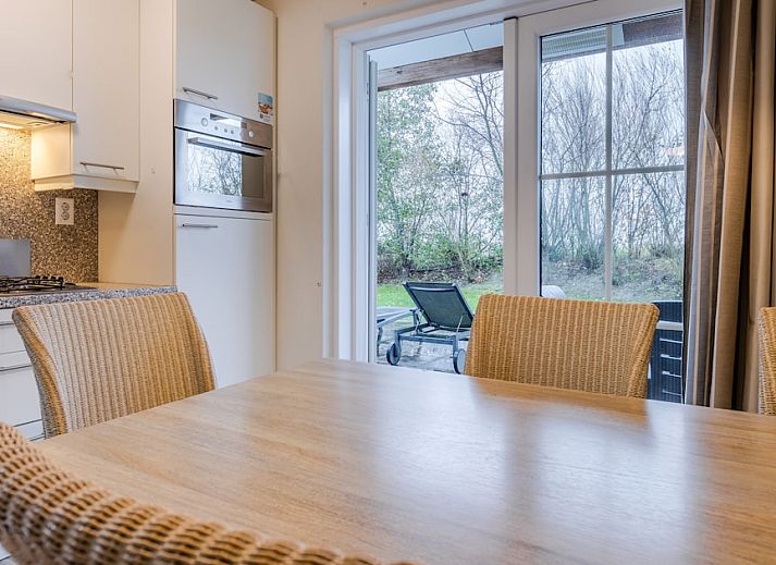 Sfeervolle slaapkamer in Villa 6B, een vakantiehuis in Cadzand-bad, Zeeuws-Vlaanderen, Zeeland, met twee comfortabele bedden en zacht licht.