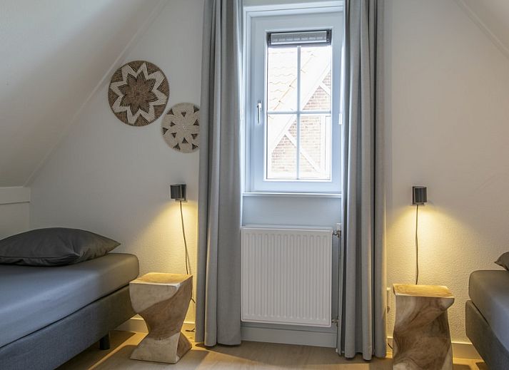 Sfeervolle slaapkamer in Villa 8B Luxe, een vakantiehuis in Cadzand-bad, Zeeuws-Vlaanderen, met rustgevend stranddecor aan de muur.