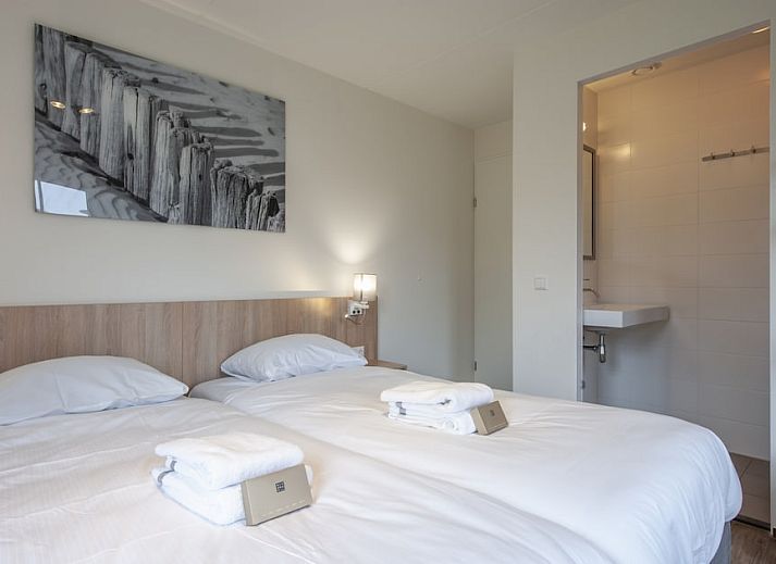 Stilvolles Wohnzimmer in Villa 10A Luxe, einem Ferienhaus in Cadzand-bad, Zeeuws-Vlaanderen, mit bequemen Sitzgelegenheiten und natuerlichem Licht.