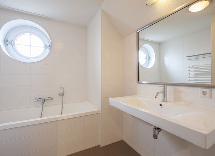 Stilvolles Wohnzimmer in Villa 10A Luxe, einem Ferienhaus in Cadzand-bad, Zeeuws-Vlaanderen, mit bequemen Sitzgelegenheiten und natuerlichem Licht.