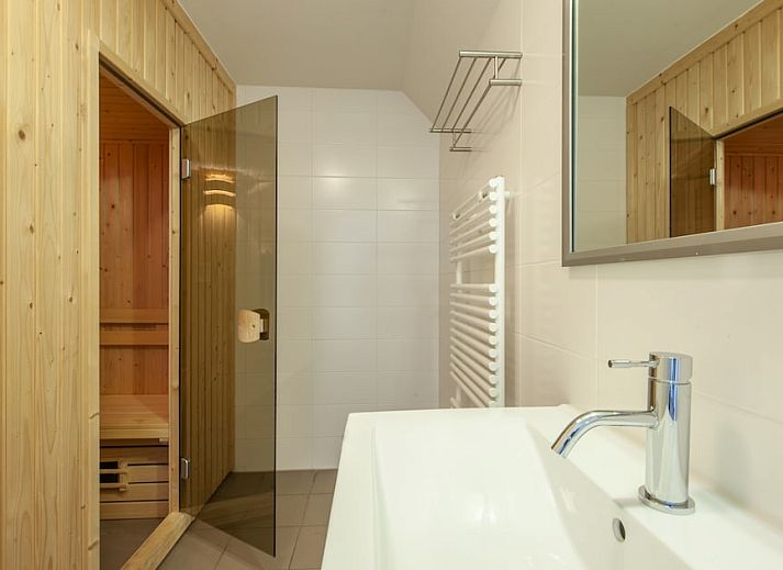 Stilvolles Wohnzimmer in Villa 10A Luxe, einem Ferienhaus in Cadzand-bad, Zeeuws-Vlaanderen, mit bequemen Sitzgelegenheiten und natuerlichem Licht.