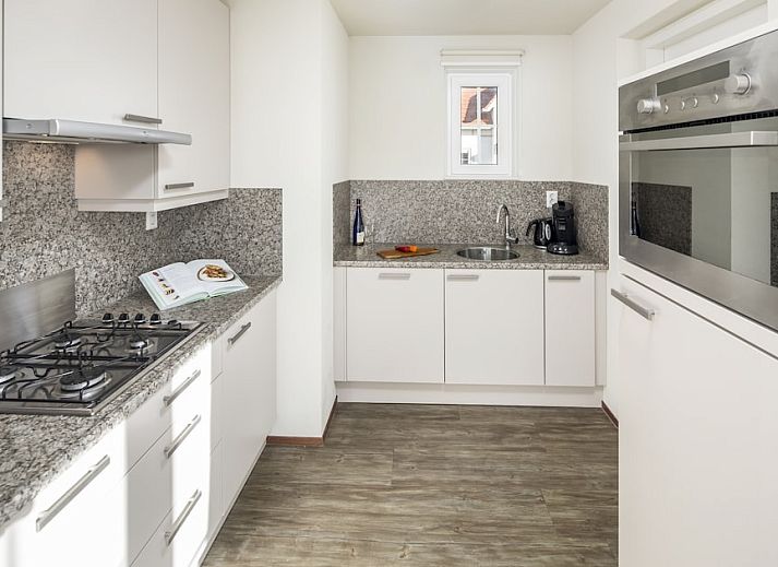 Villa 5A in Cadzand-bad, Zeeuws-Vlaanderen, Zeeland, een charmant vakantiehuis met rode daken en groene omgeving.