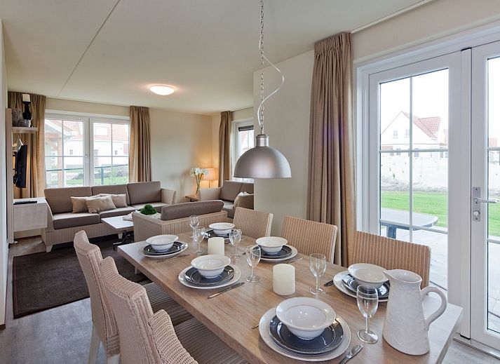 Gezellige woonkamer in Villa 6A, een vakantiehuis in Cadzand-bad, Zeeuws-Vlaanderen, met comfortabele banken en uitzicht op de natuur.