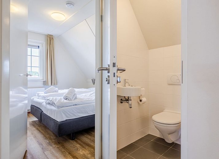 Gezellige slaapkamer in Villa 9A, vakantiehuis in Cadzand-bad, Zeeuws-Vlaanderen, met veel natuurlijk licht en uitzicht op de omgeving.