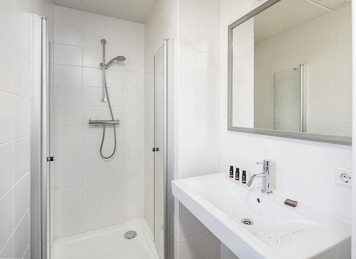 Gezellige woonkamer in Watervilla 8C, vakantiehuis in Cadzand-bad, Zeeuws-Vlaanderen, Zeeland met comfortabele zitbanken en veel natuurlijk licht.