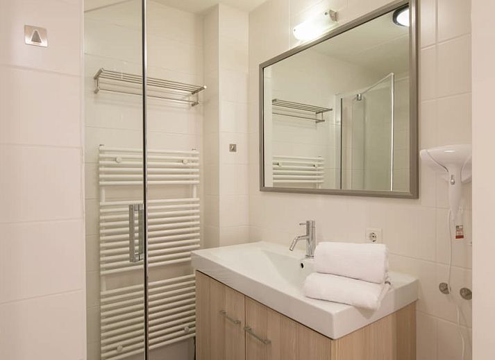 Gezellige woonkamer in Familievilla 12 Luxe, vakantiehuis in Cadzand-bad, Zeeuws-Vlaanderen, met comfortabele zithoek en veel natuurlijk licht.