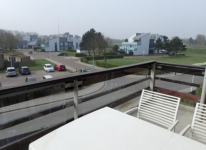 Blick vom Balkon der Ferienwohnung VZ922 in Cadzand, mit Blick auf moderne Architektur und gruene Umgebung in Zeeland.