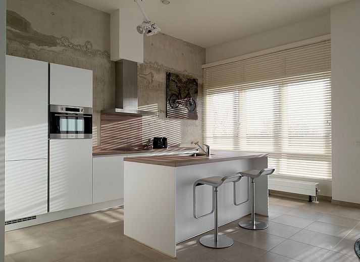 Penthouse 5 in Cadzand-bad, Zeeuws-Vlaanderen biedt een ruime, moderne woonkamer met veel natuurlijk licht en stijlvolle inrichting.