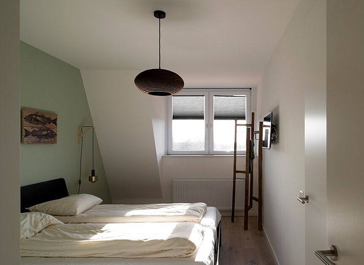Penthouse 5 in Cadzand-bad, Zeeuws-Vlaanderen biedt een ruime, moderne woonkamer met veel natuurlijk licht en stijlvolle inrichting.