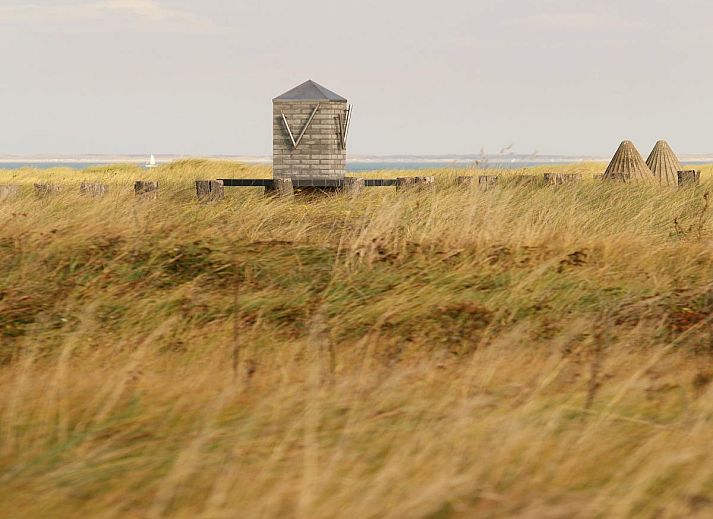 Eethoek in vakantiehuis Maanvis, Cadzand, Zeeuws-Vlaanderen met houten meubels en sfeervolle verlichting.