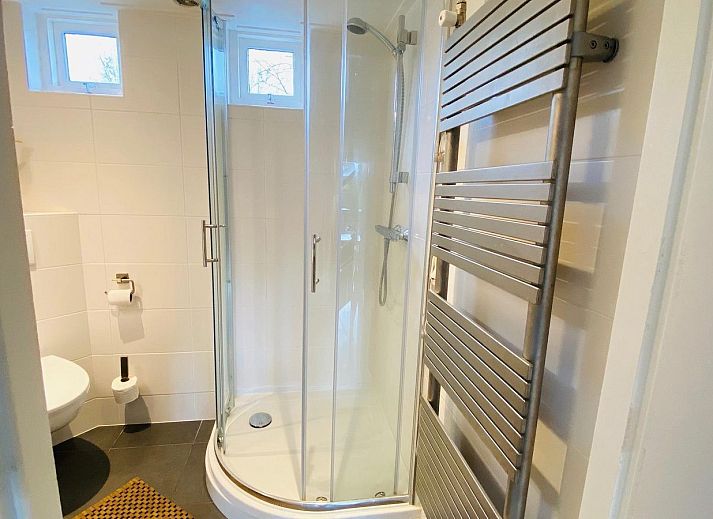 Tuin met ligstoelen bij VZ702 Vakantiehuis Cadzand in Cadzand, Zeeuws-Vlaanderen, perfect voor ontspanning.