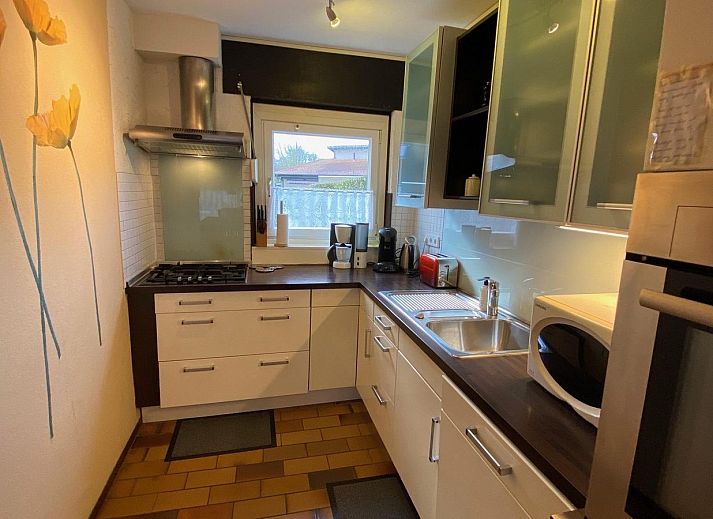 Sonnige Terrasse bei VZ643 Vakantiewoning Cadzand, Ferienhaus in Cadzand, Zeeuws-Vlaanderen, mit gruenen Hecken.