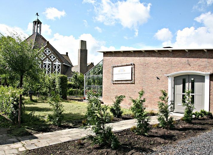 Eko Zonnehuis bungalow in Schoondijke with glass conservatory and green garden in Zeeuws-Vlaanderen, Zeeland.