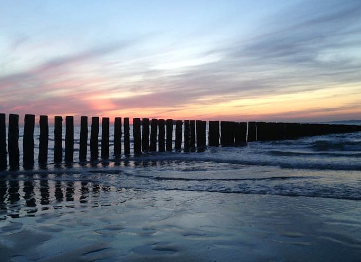 Stilvolles Wohnzimmer im Ferienhaus in Schoondijke, Zeeuws-Vlaanderen, mit einem bequemen braunen Ledersofa und Blick auf die natuerliche Umgebung.
