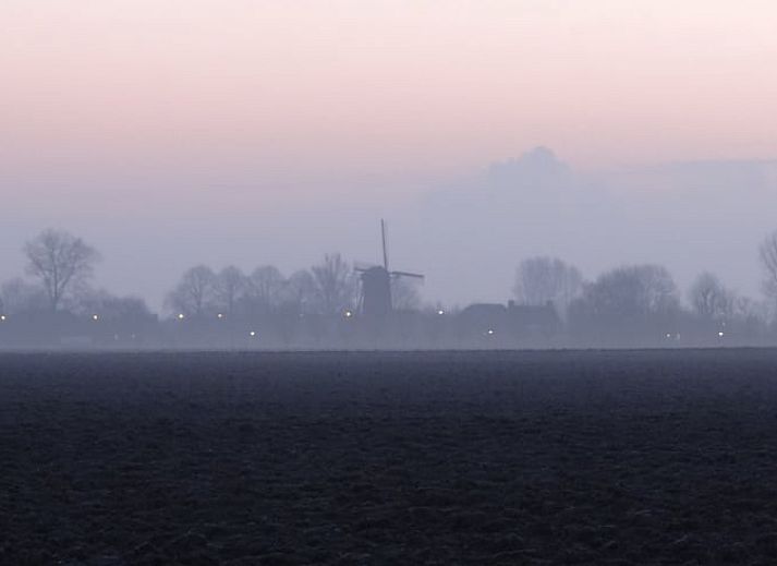 Stilvoller Innenraum des Ferienhauses in Schoondijke, Zeeuws-Vlaanderen, mit grossen Fenstern und einer gemuetlichen Sitzecke.